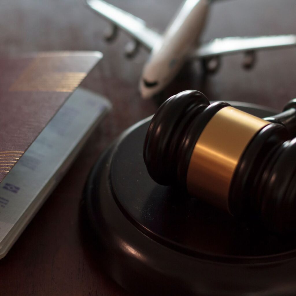 lawyer gavel sitting next to model airplane and passport