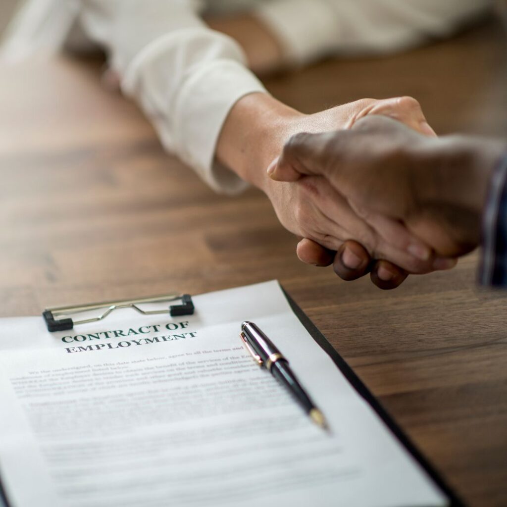 two people shaking hands over employment application