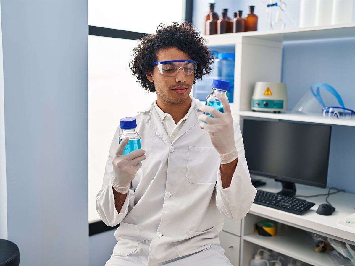 Hispanic man in lab looking at chemicals