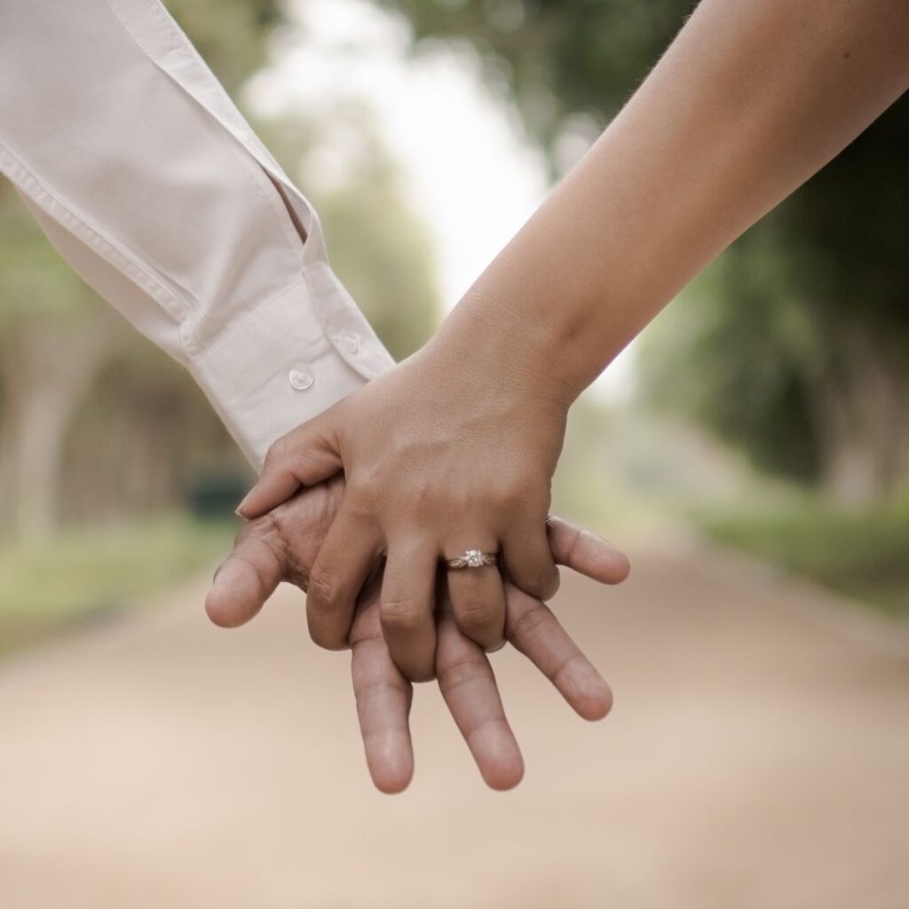 couple holding hands to show woman's wedding ring